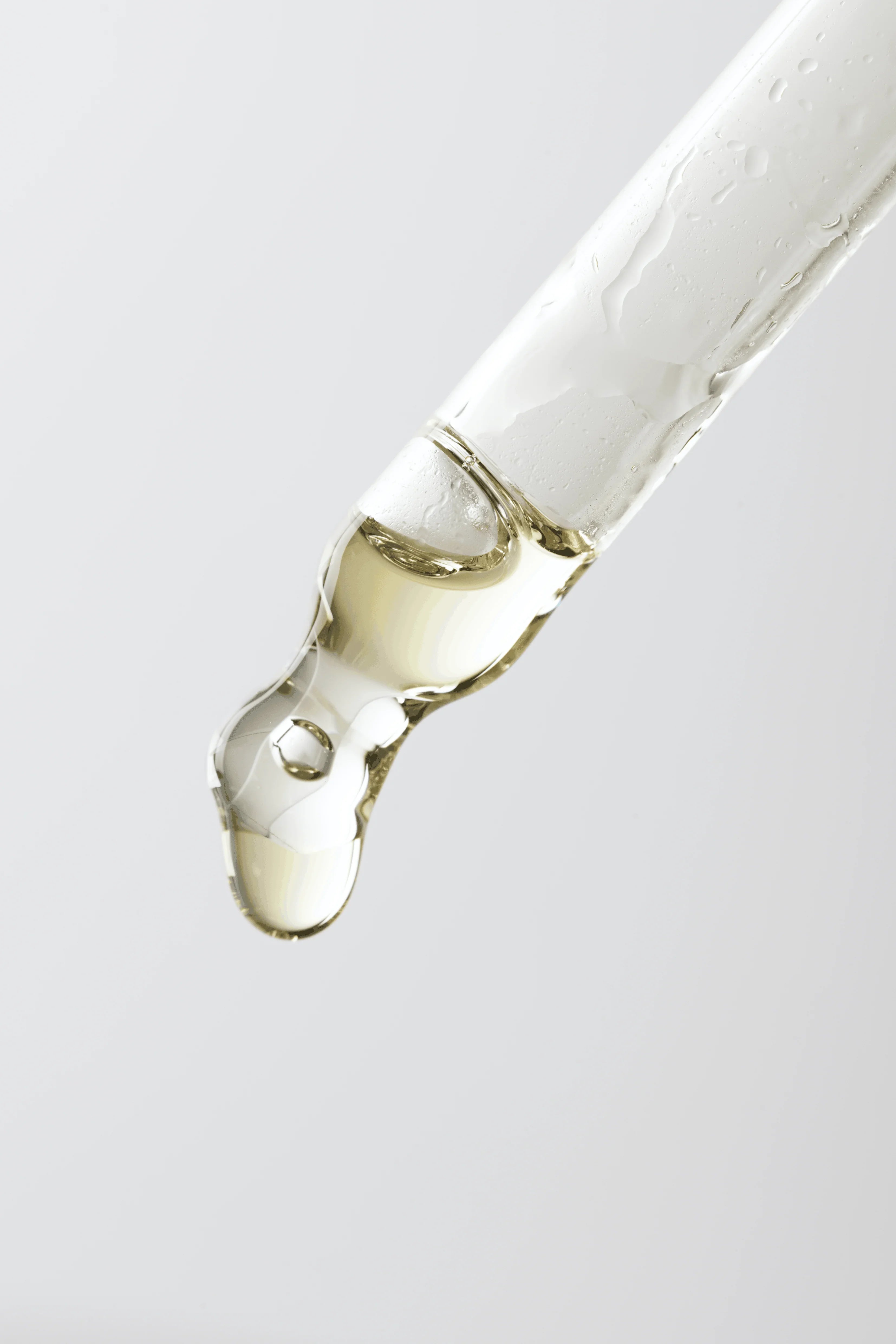 Radiance Face Oil bottle with its silver dropper on a light background