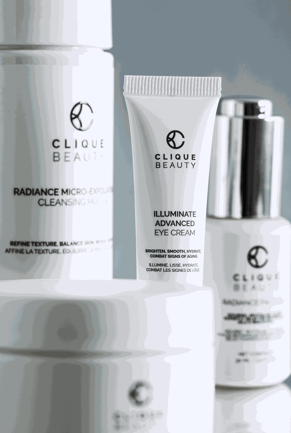 Clique Beauty skincare products including a cleanser, eye cream, and serum on a gray background.