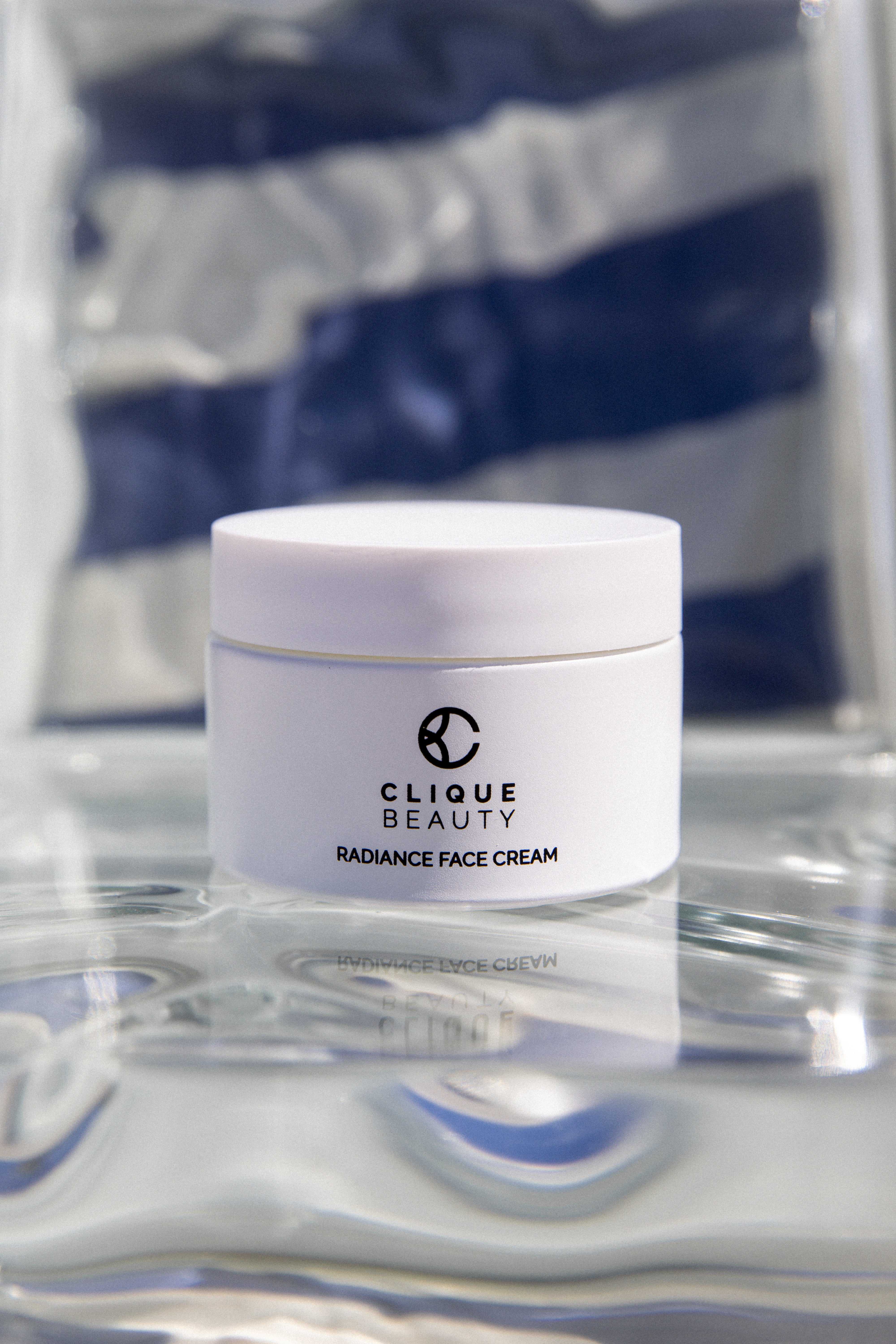 Clique Beauty Radiance Face Cream jar held in natural daylight