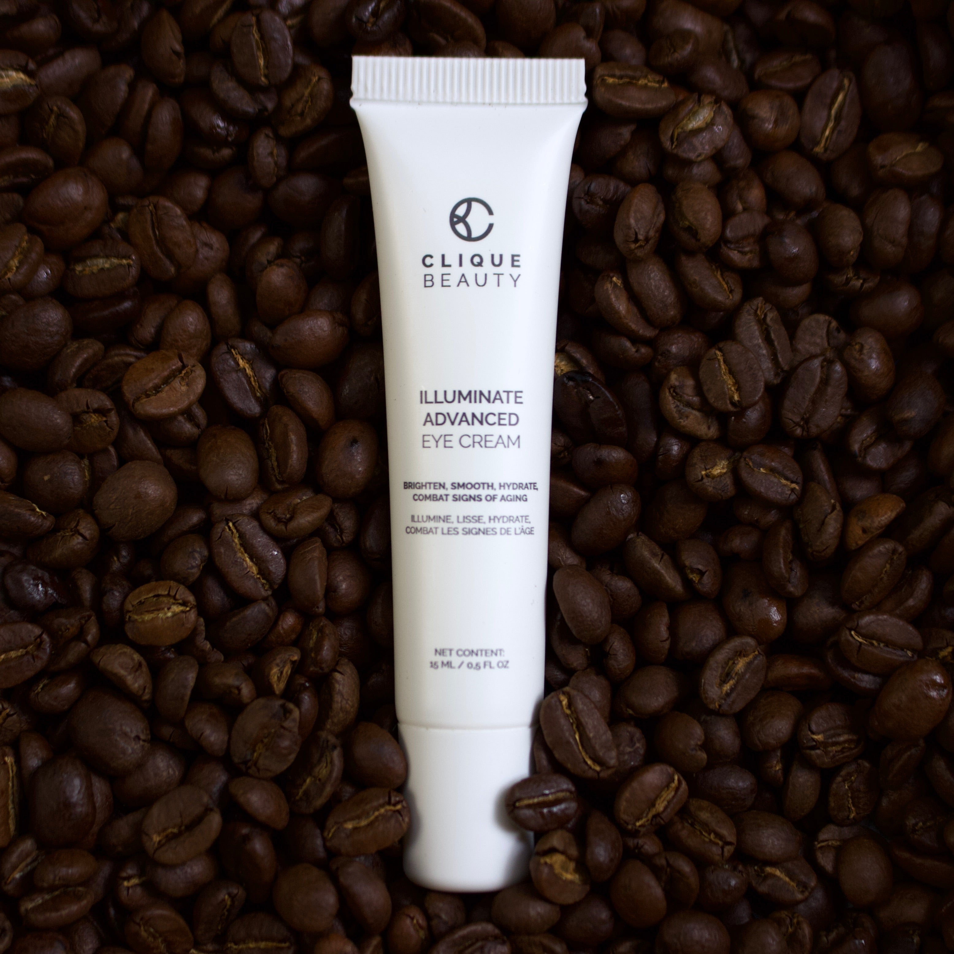Tube of Clique Beauty Illuminate Advanced Eye Cream on a bed of coffee beans