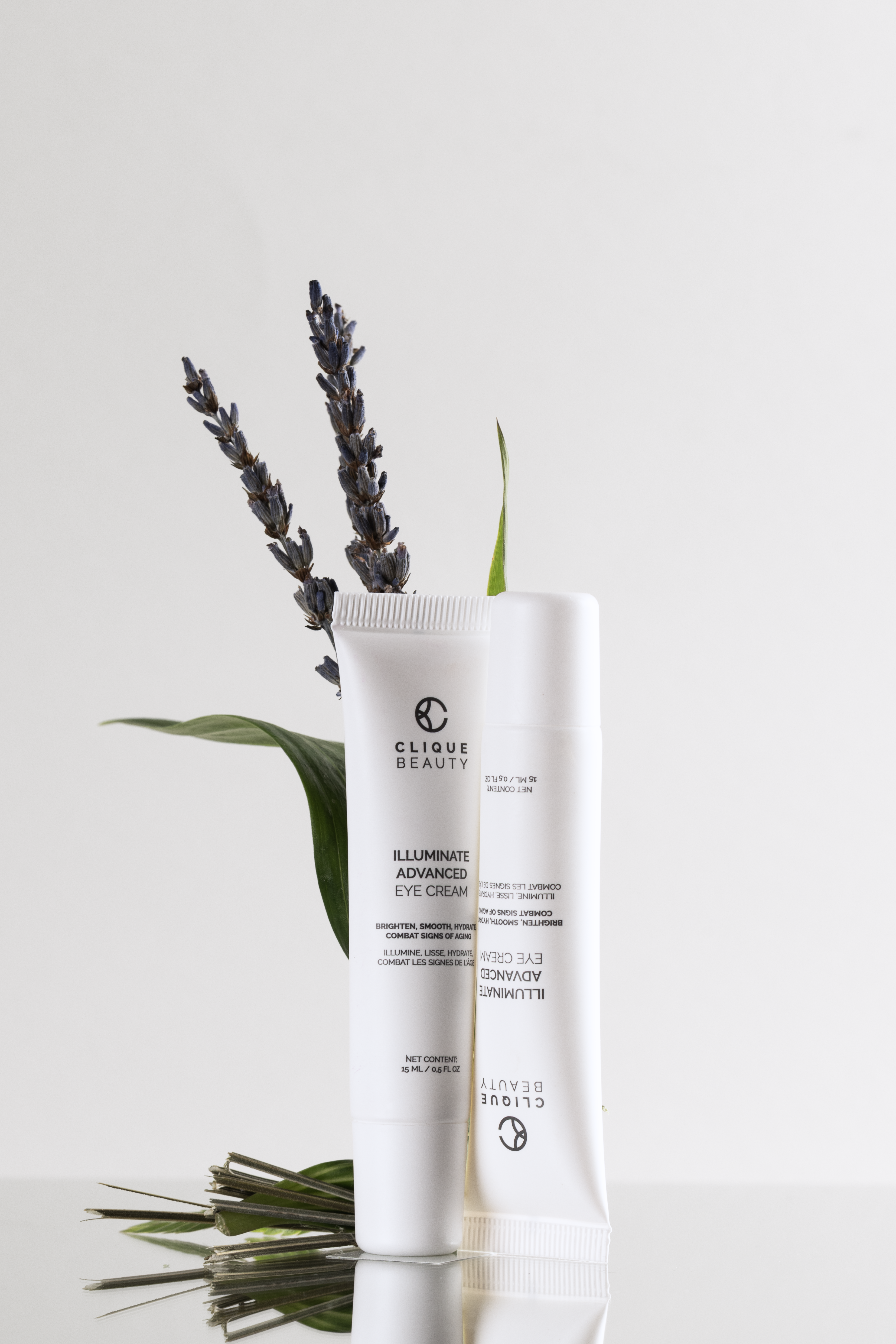 Two skincare products with lavender and green leaves on a light gray background